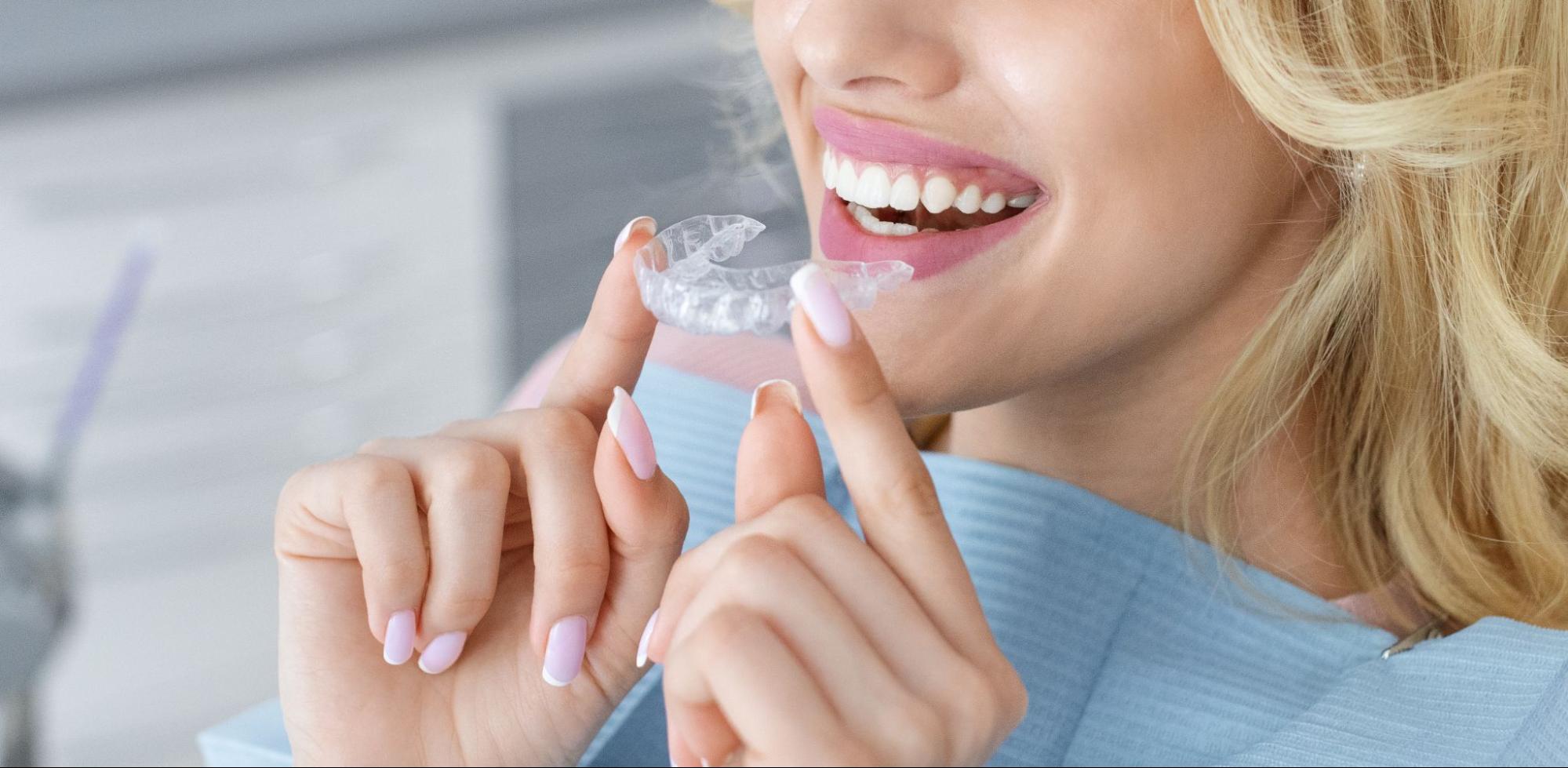 Patient holding a clear aligner tray near their mouth at Alba Orthodontics in Harrisburg