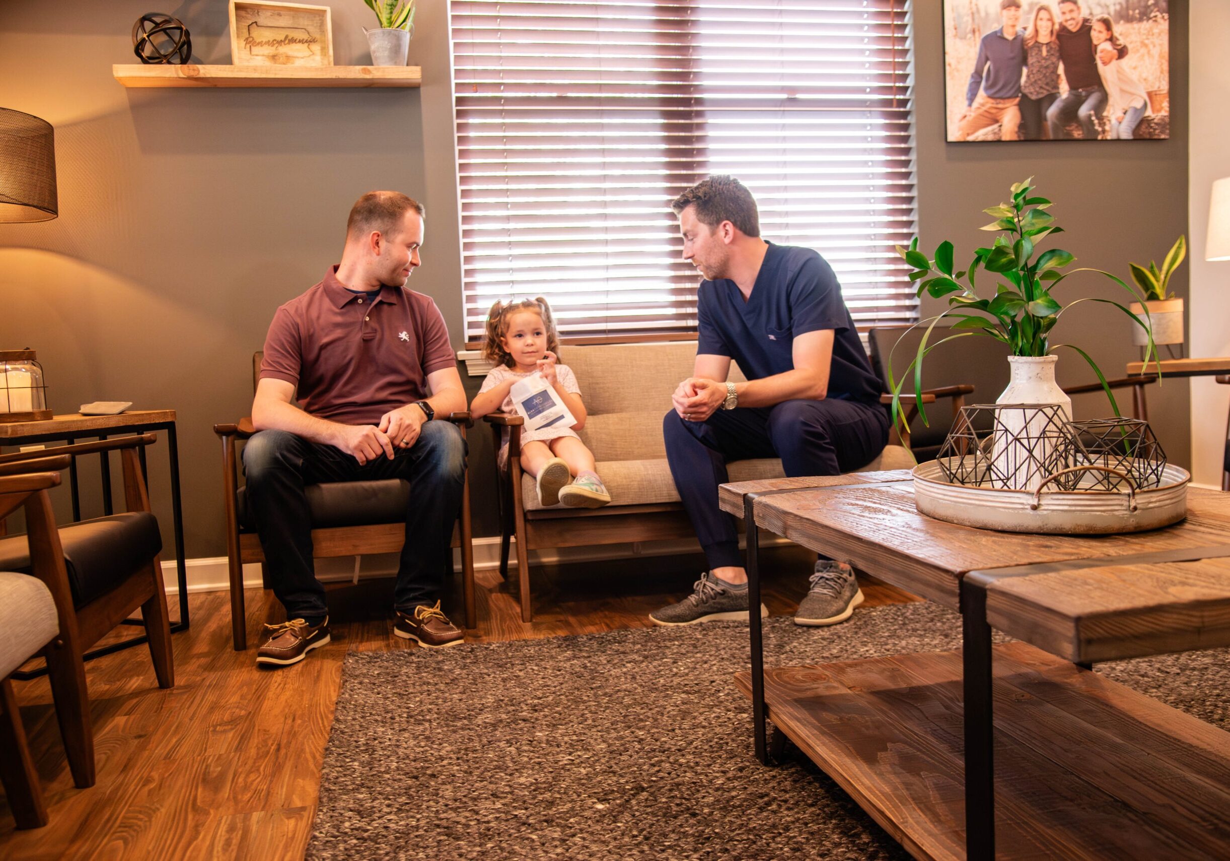 Doctor talking with young female and adult male patients