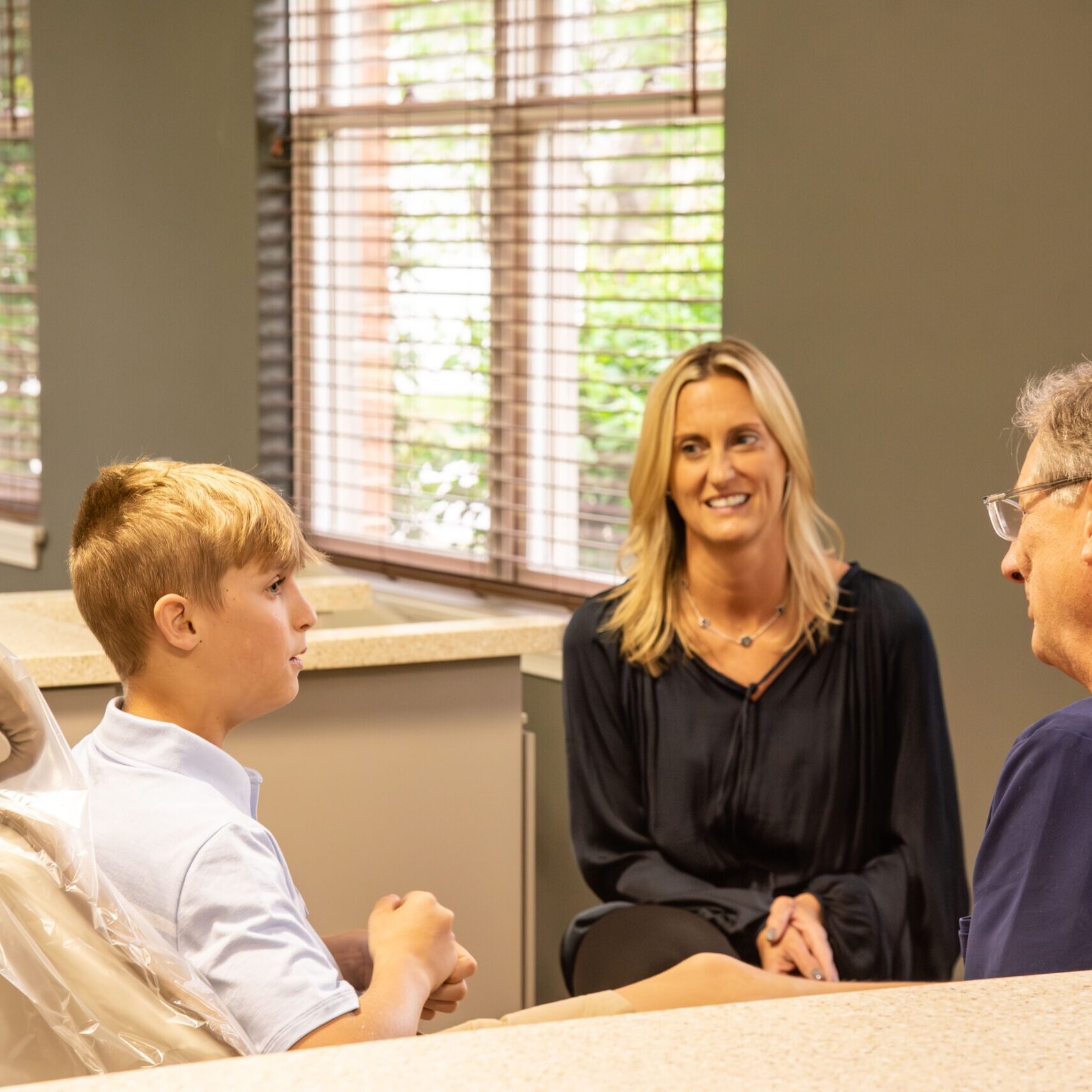 Teen patient talking with doctor and parent